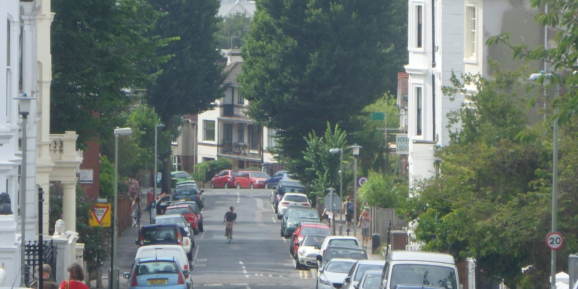 Cars parked along Clifton Hill in Montpelier, Brighton, between stucco terraces