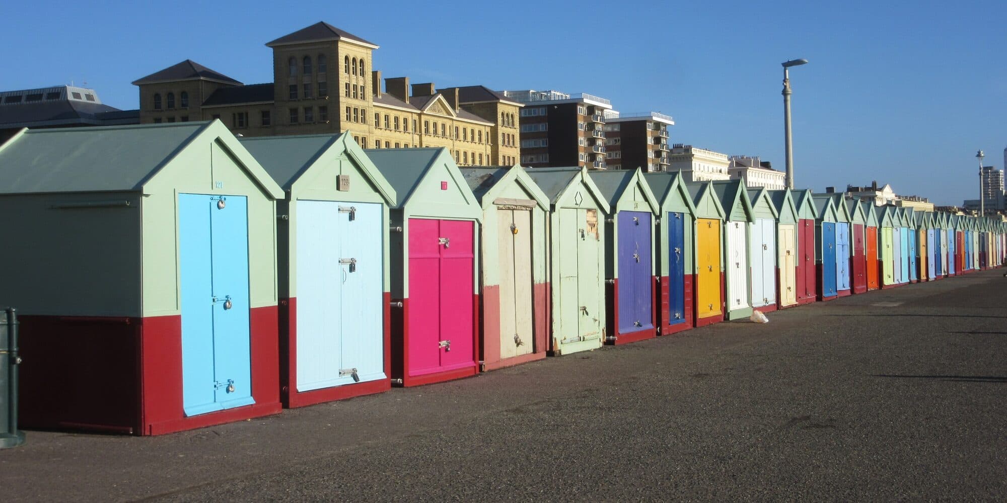 A long row of painted beach huts along King's Esplanade, Hove