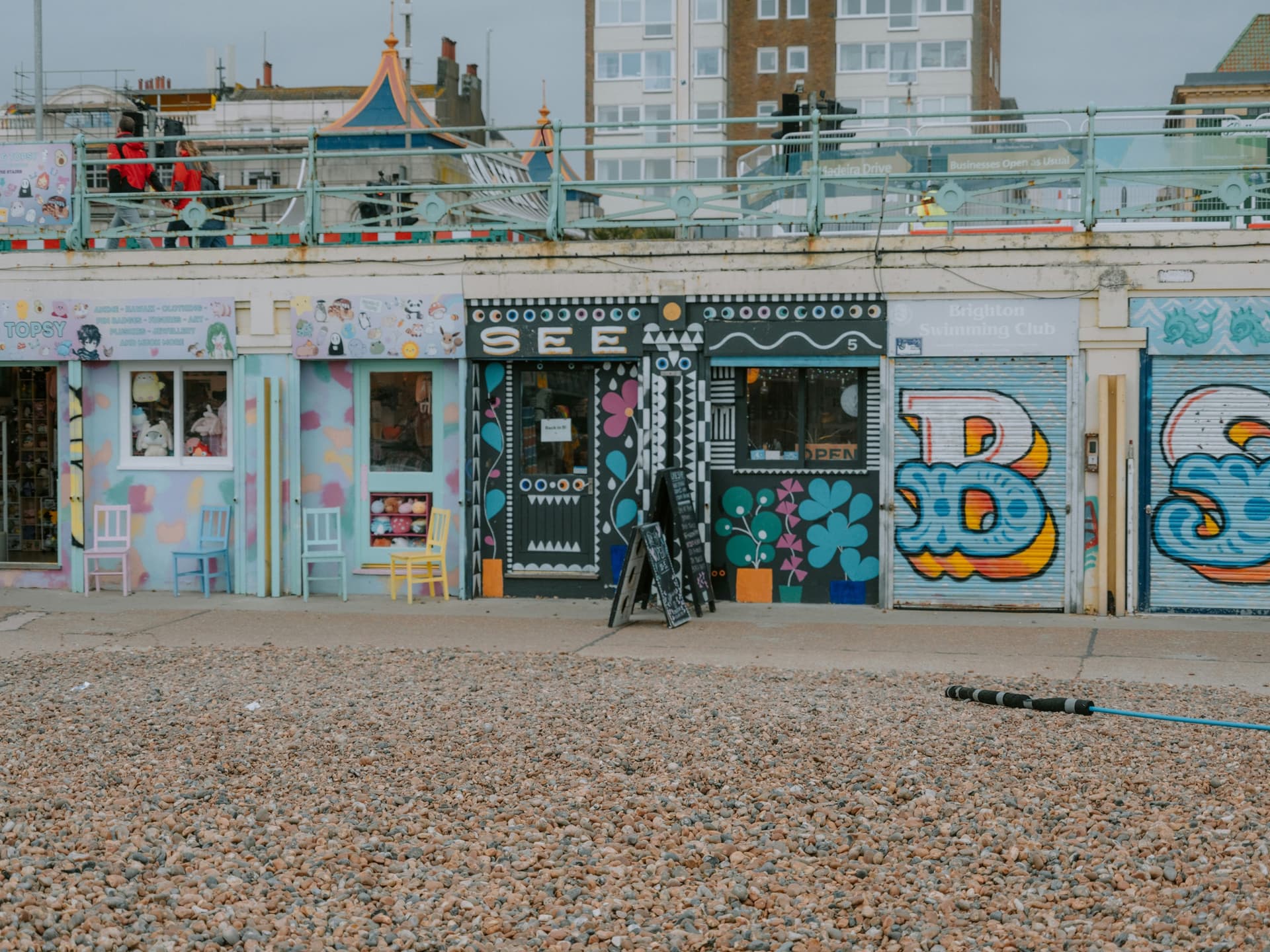 Graffiti-painted shopfronts on Brighton's pebble beachfront