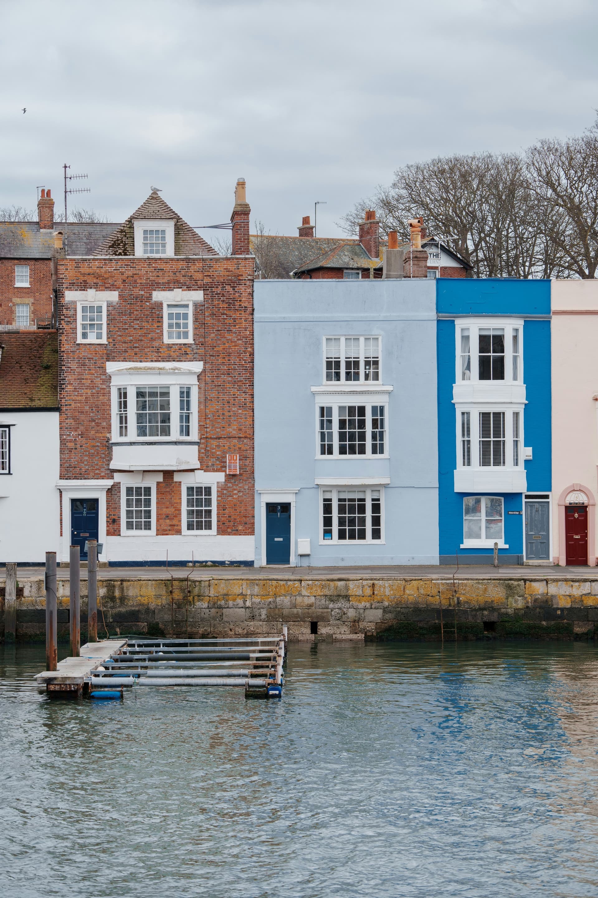 Colourful coastal townhouses facing a quiet tidal quay