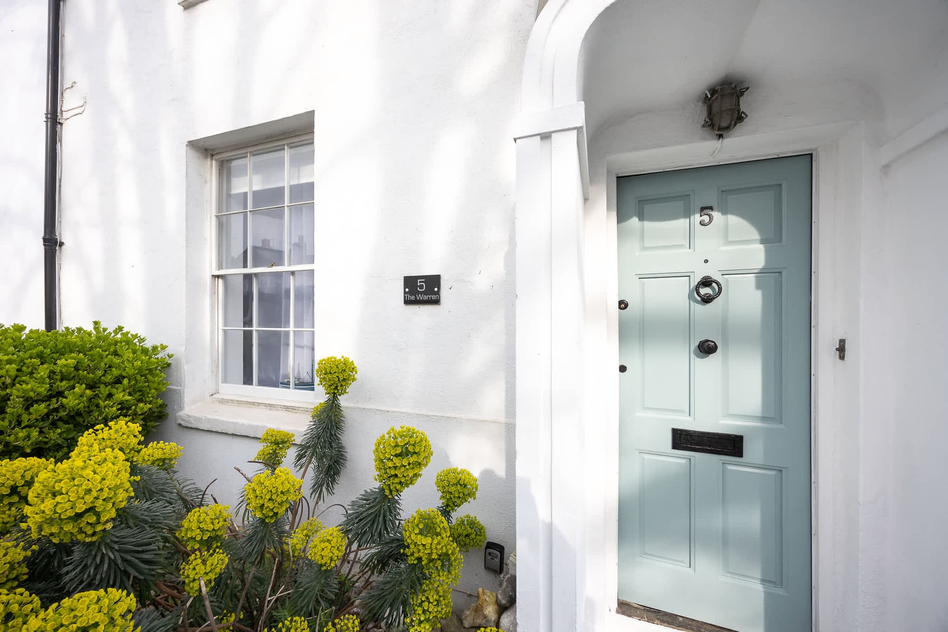 The pastel-blue front door of Jenny's historic Worthing townhouse