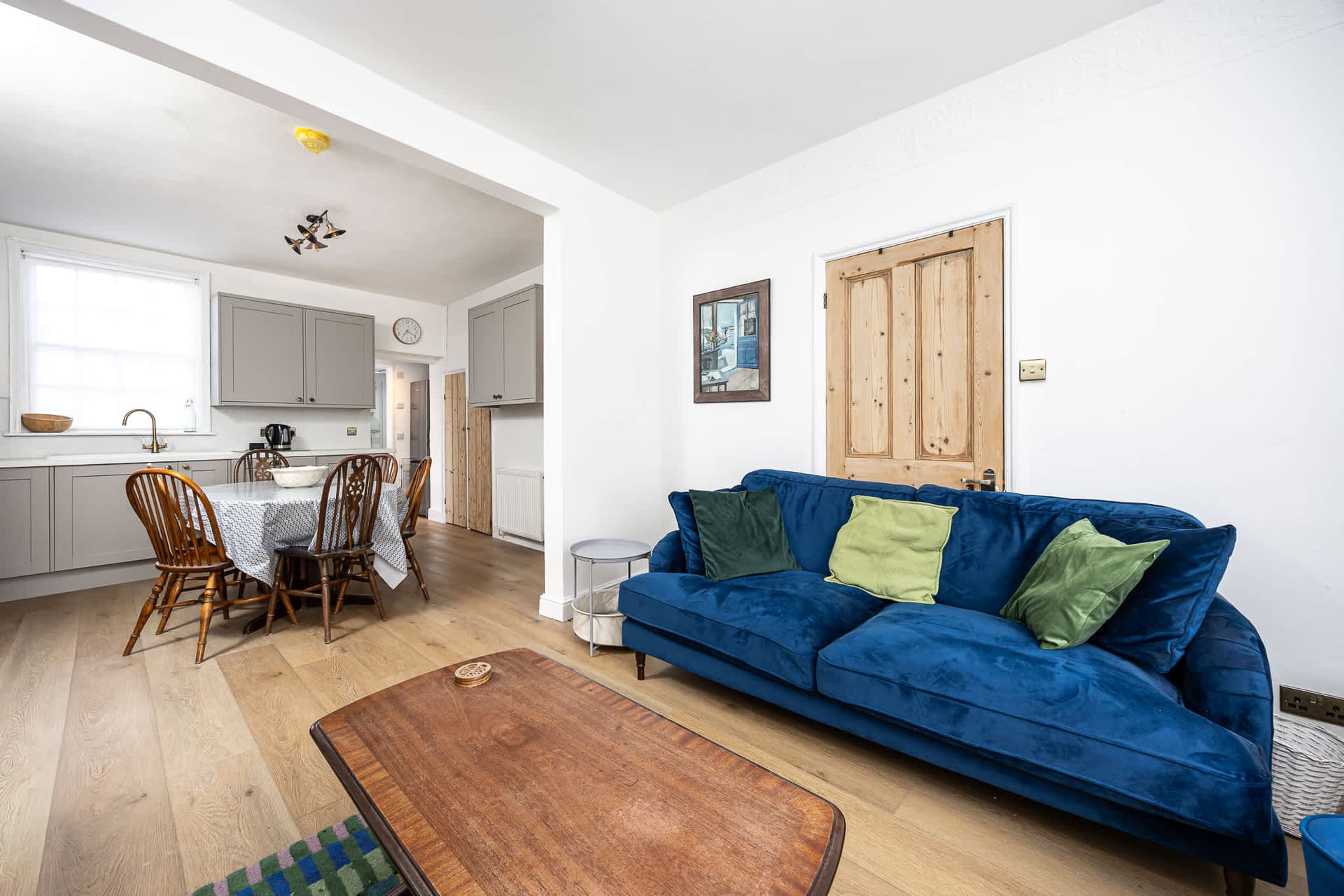 Comfortable seating area with a deep sofa and central coffee table, creating an easy, relaxed space to unwind. Light-filled and simply styled, it’s ideal for reading, chatting or settling in after a day by the sea.