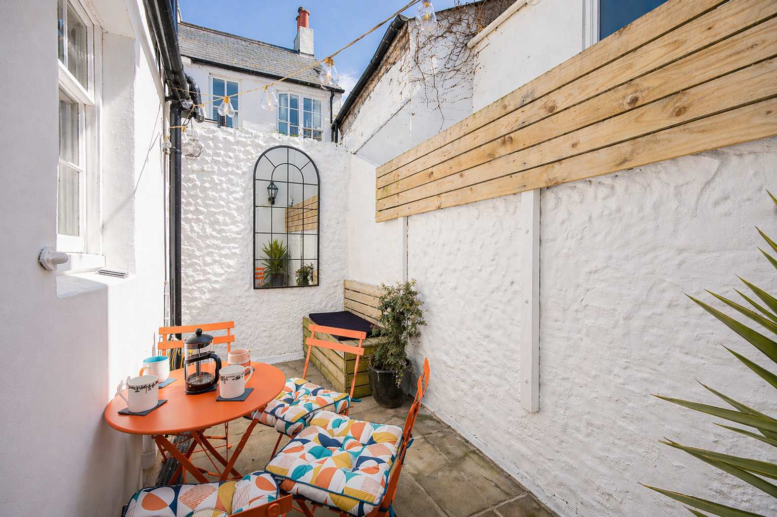 Courtyard patio table set for morning coffee at a South House cottage in Brighton