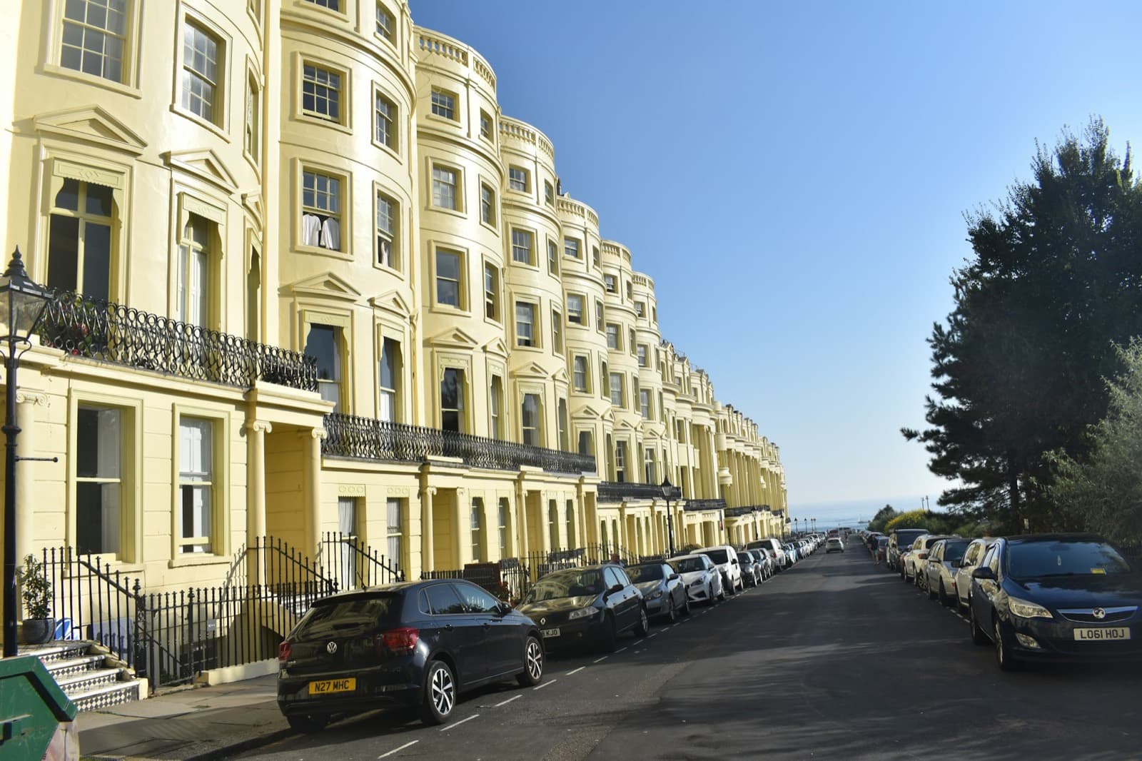 A curving Regency terrace of cream seafront apartments running down towards the sea